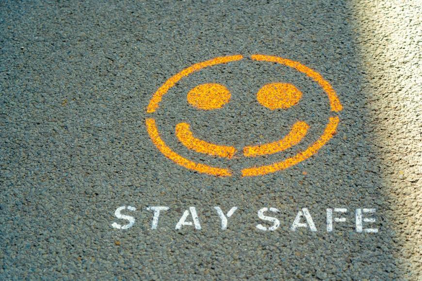 grey asphalt smiley face, stay safe text