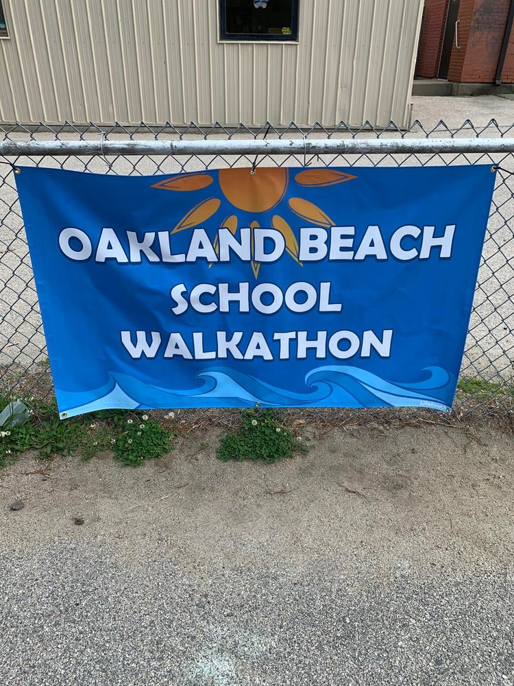 Oakland Beach School Walkathon text, blue banner hanging on fence