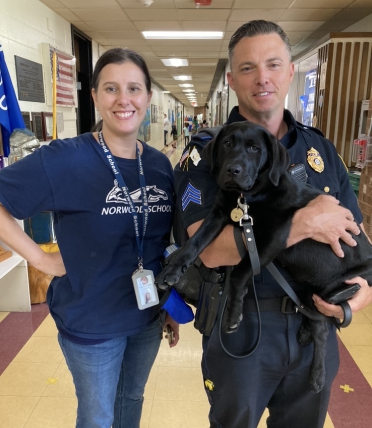 adult female, adult male officer, black lab puppy 