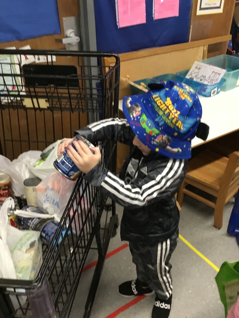 One of our preschoolers showing school spirit with their crazy hat and another dropping off his canned good for our school pantry.