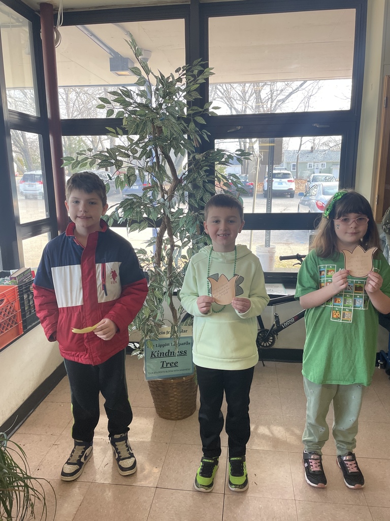 Three students holding kindness flowers