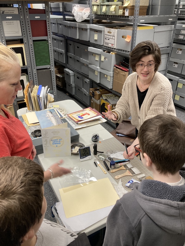 Students learning how to test the age of paper in the archives of the Steamship Historical Society